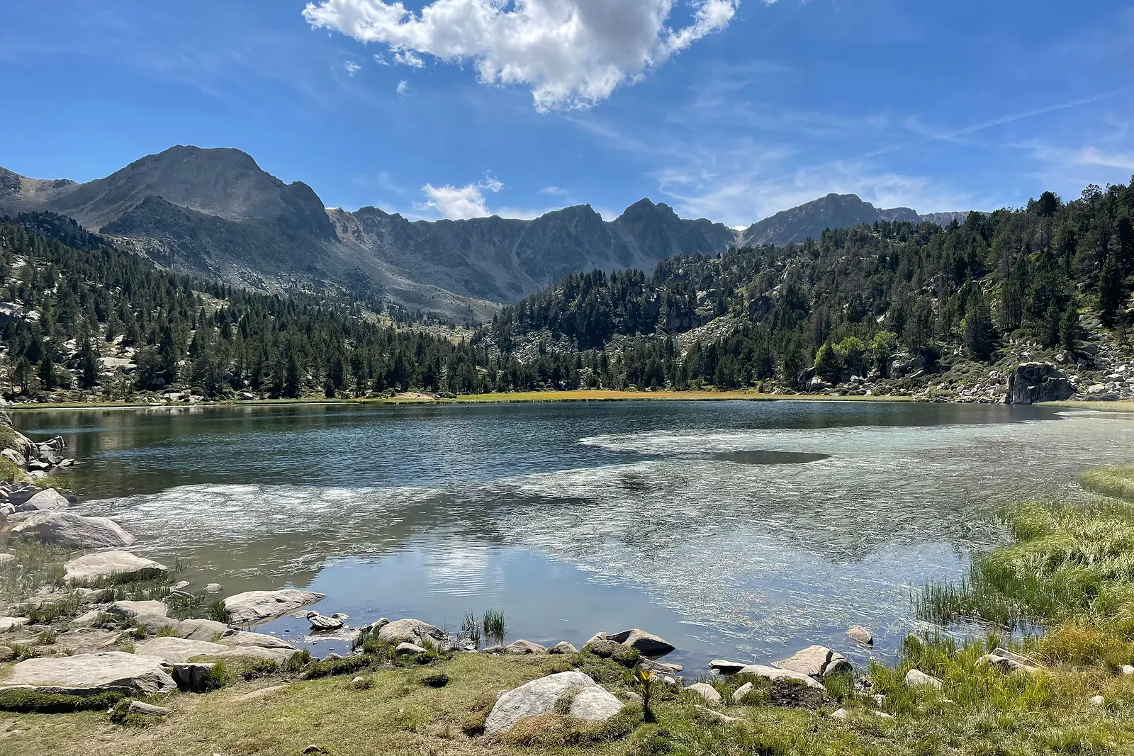 Lago de montaña rodeado de cumbres en el Pirineo